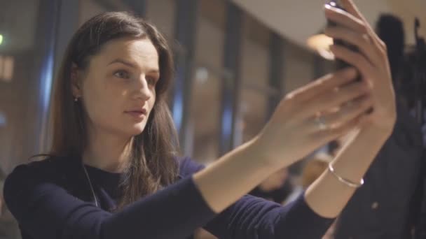 Hezká dívka baví a přitom selfie na mobilních zařízeních v kavárně. — Stock video