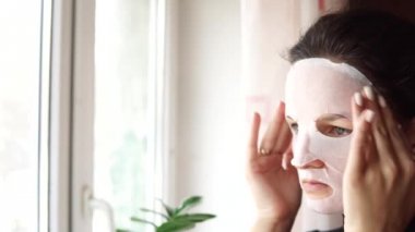 Genç kadının yapması ile yüzünde maske arındırıcı yüz maskesi sayfası.