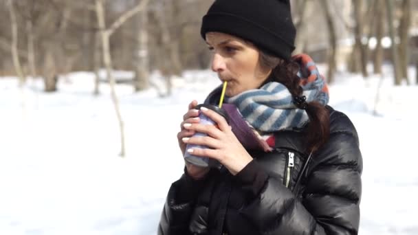 Gefrorenes Mädchen trinkt im Winter Kaffee auf der Straße — Stockvideo