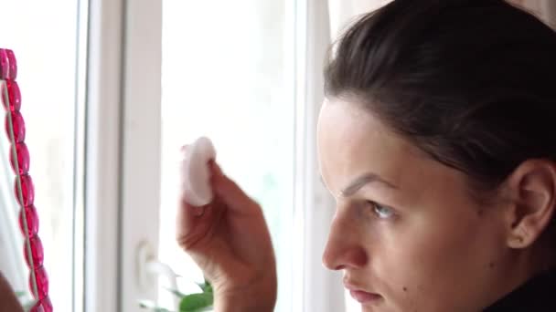 Young beautiful girl with cotton swab cleaning her face. — Stock Video