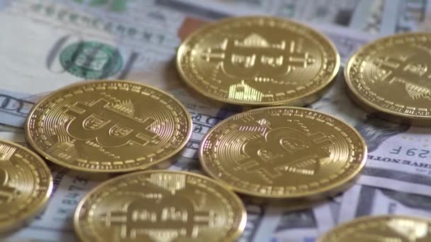 Монеты Bitcoin BTC вращаются на долларовых купюрах. Виртуальная криптовалюта . — стоковое видео