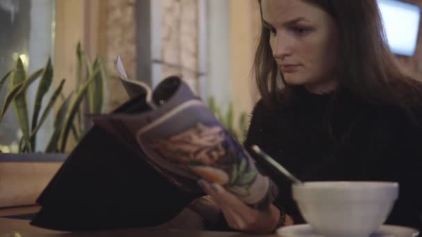 Γυναίκα ψάχνει μέσα από το μενού στο εστιατόριο — Αρχείο Βίντεο