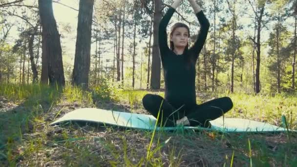 Joven embarazada haciendo yoga fuera . — Vídeo de stock