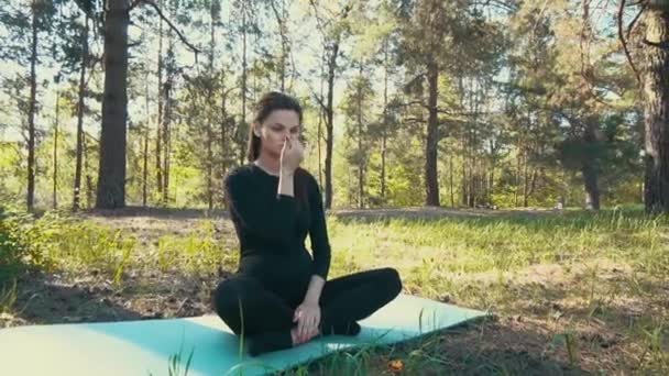 Joven embarazada haciendo yoga fuera . — Vídeo de stock