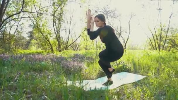 Unga gravid kvinna gör yoga utanför. — Stockvideo