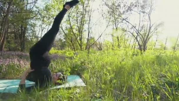 Joven embarazada haciendo yoga fuera . — Vídeo de stock