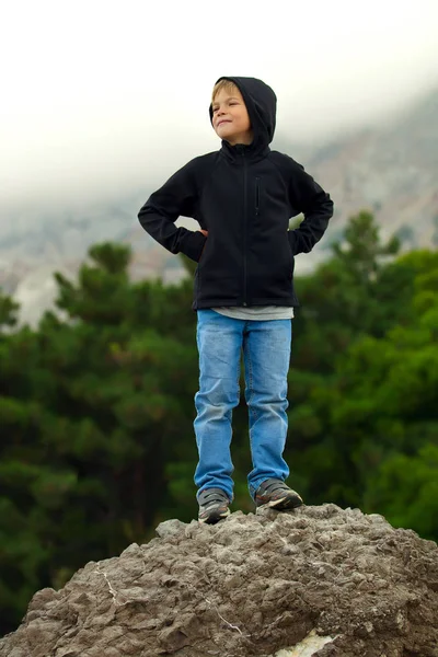 Turystyczna nastolatek chłopiec stojący na skale i uśmiechając się — Zdjęcie stockowe