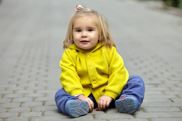 Niña sentada en un camino en el parque —  Fotos de Stock