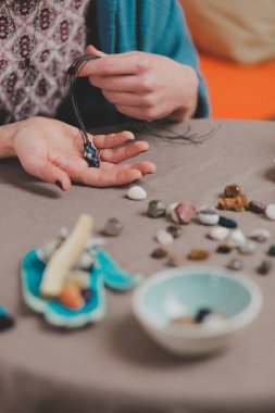El yapımı mücevher yapan bir kadın, ev yapımı atölye çalışması. Zanaatkar kadın mücevher üretir. Sanat, hobi, el işi konsepti