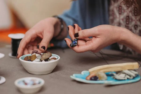 El yapımı mücevher yapan bir kadın, ev yapımı atölye çalışması. Zanaatkar kadın mücevher üretir. Sanat, hobi, el işi konsepti