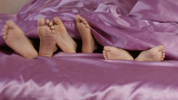 Feet sticking from under blanket. — Stock Video