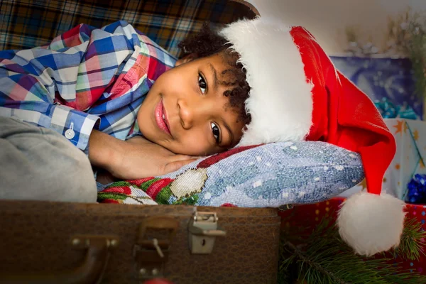 Niño de Navidad tendido cerca de regalos . — Foto de Stock