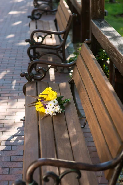 Bouquet on wooden bench. — Stock Photo, Image