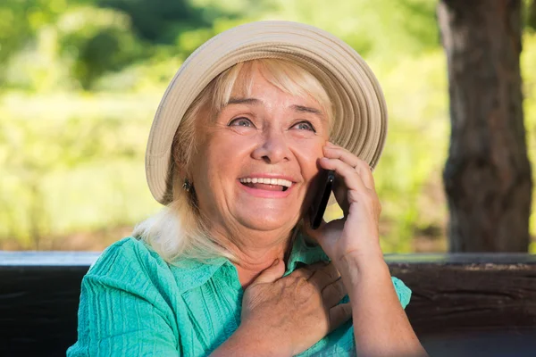 Улыбающаяся взрослая женщина с телефоном . — стоковое фото
