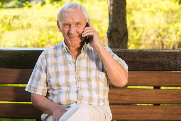 Smiling elderly man with phone.