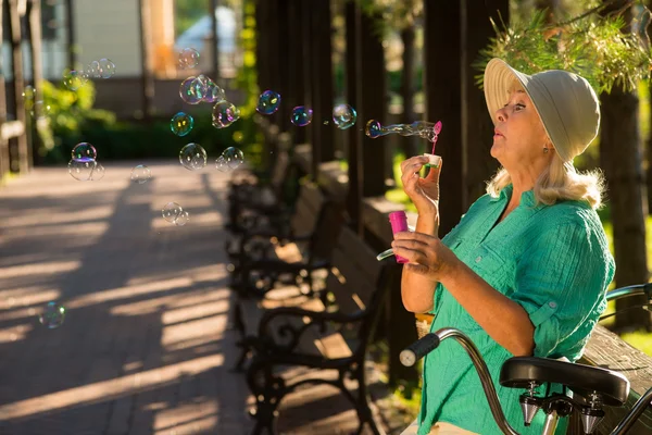Старшая женщина, пускающая пузыри . — стоковое фото