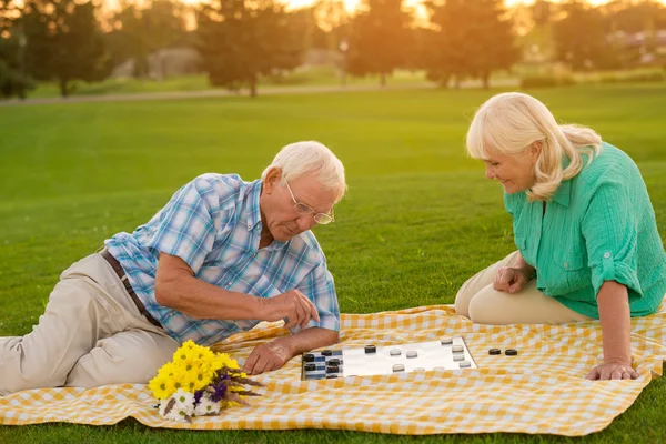 Senior couple playing checkers. — Stock Photo, Image