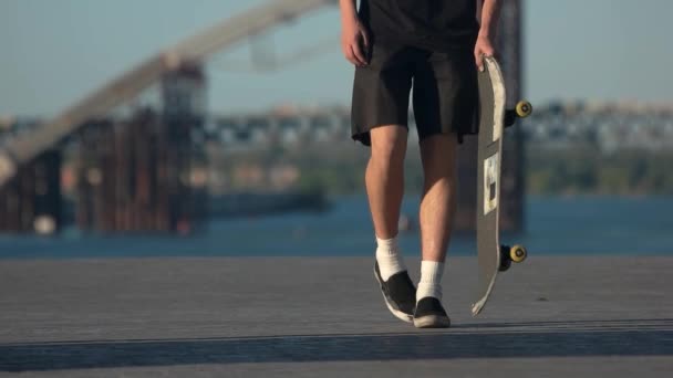 Jovem com um skate. — Vídeo de Stock