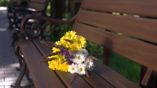 Bouquet on brown bench. — Stock Video