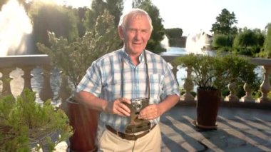 Gülümseyen ve kamera tutan adam.