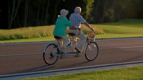 Seniorenpaar fährt Tandemfahrrad. — Stockvideo