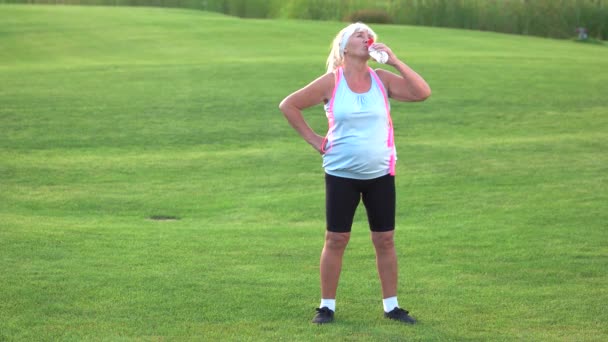 Old woman with sports bottle. — Stock Video