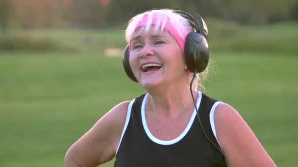 Mujer mayor con auriculares . — Vídeos de Stock