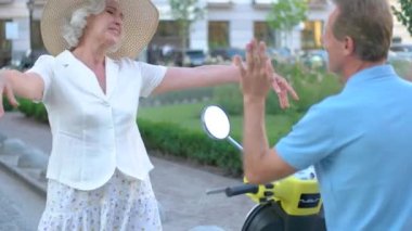 Kadın kucaklama adam scooter üzerinde.