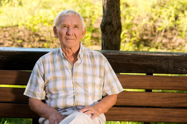Homme âgé assis sur le banc . — Photo