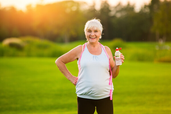 Woman with water bottle smiling.