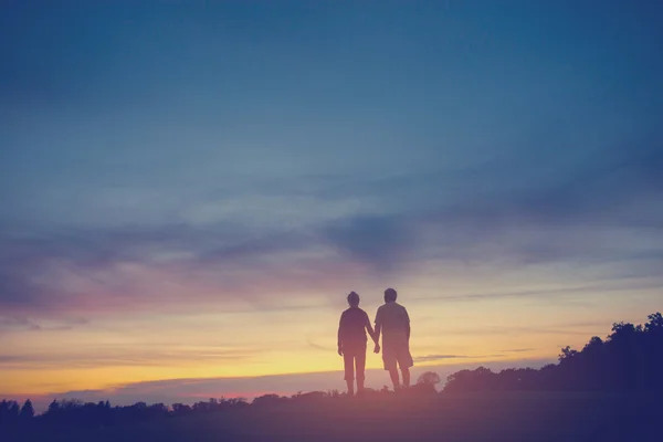 Koppel op achtergrond van zonsondergang. — Stockfoto