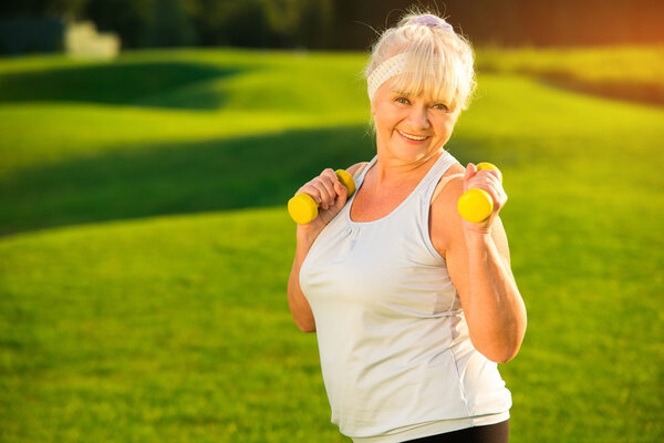 Elderly woman with dumbbells.