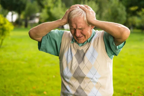 Senior man holds his head. — Stock Photo, Image