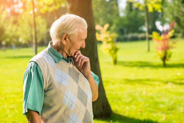 Hombre mayor tocándose la barbilla . — Foto de Stock