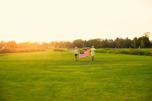 Gente corriendo y portando bandera . — Foto de Stock