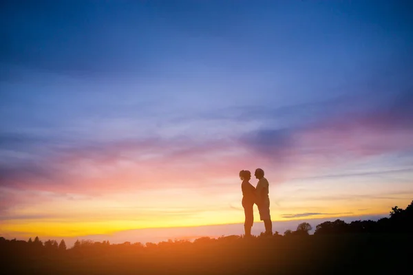 Paar staande op zonsondergang achtergrond. — Stockfoto