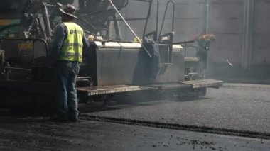 İşçi ve asfalt finişer makine.