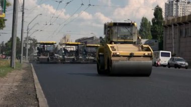 Sokakta asfalt silindirleri.