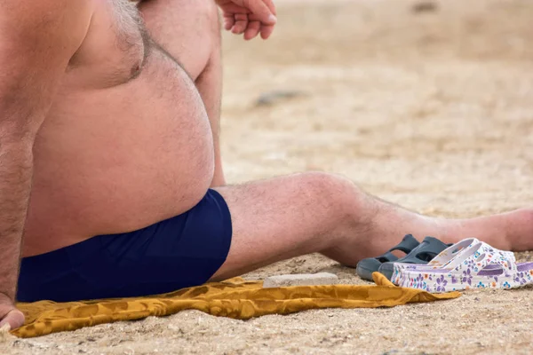 Grasso ragazzo seduto sulla spiaggia . — Foto Stock