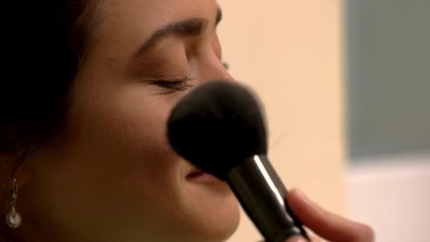 Borste applicerar makeup på kvinna. — Stockvideo