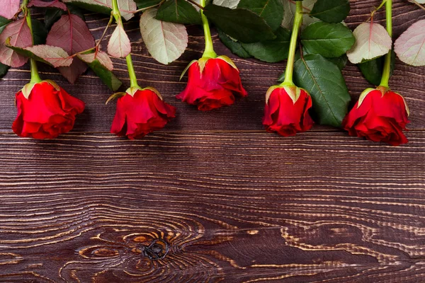 Červené růže na dřevěném pozadí. — Stock fotografie