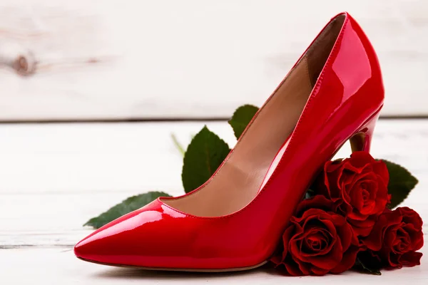 Zapato y rosas sobre madera . — Foto de Stock