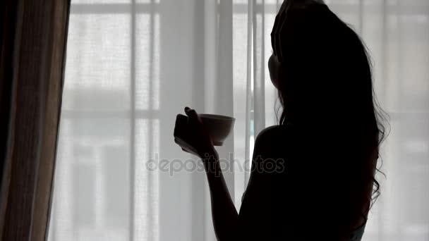 Silhouette de femme tenant tasse . — Video