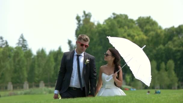 Groom and bride with umbrella. — Stock Video