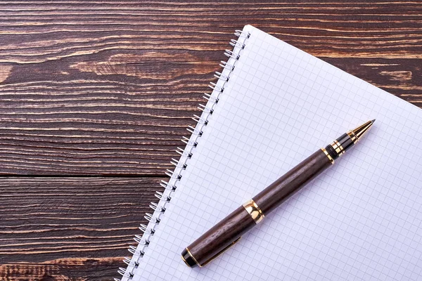 Caderno e caneta sobre madeira . — Fotografia de Stock