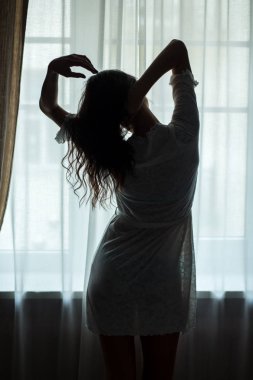 Kadın pencere duruyor.