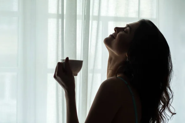 Женщина держит чашку и улыбается . — стоковое фото