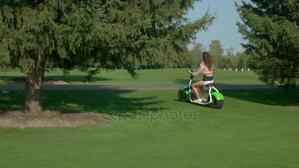 Señora está conduciendo scooter eléctrico . — Vídeos de Stock