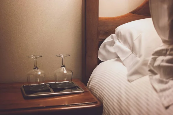 Baki dengan gelas anggur di dekat tempat tidur . — Stok Foto