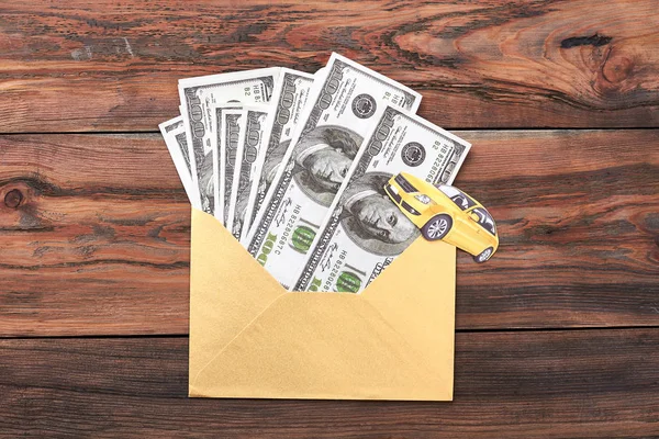 Envelope with dollars on wood.